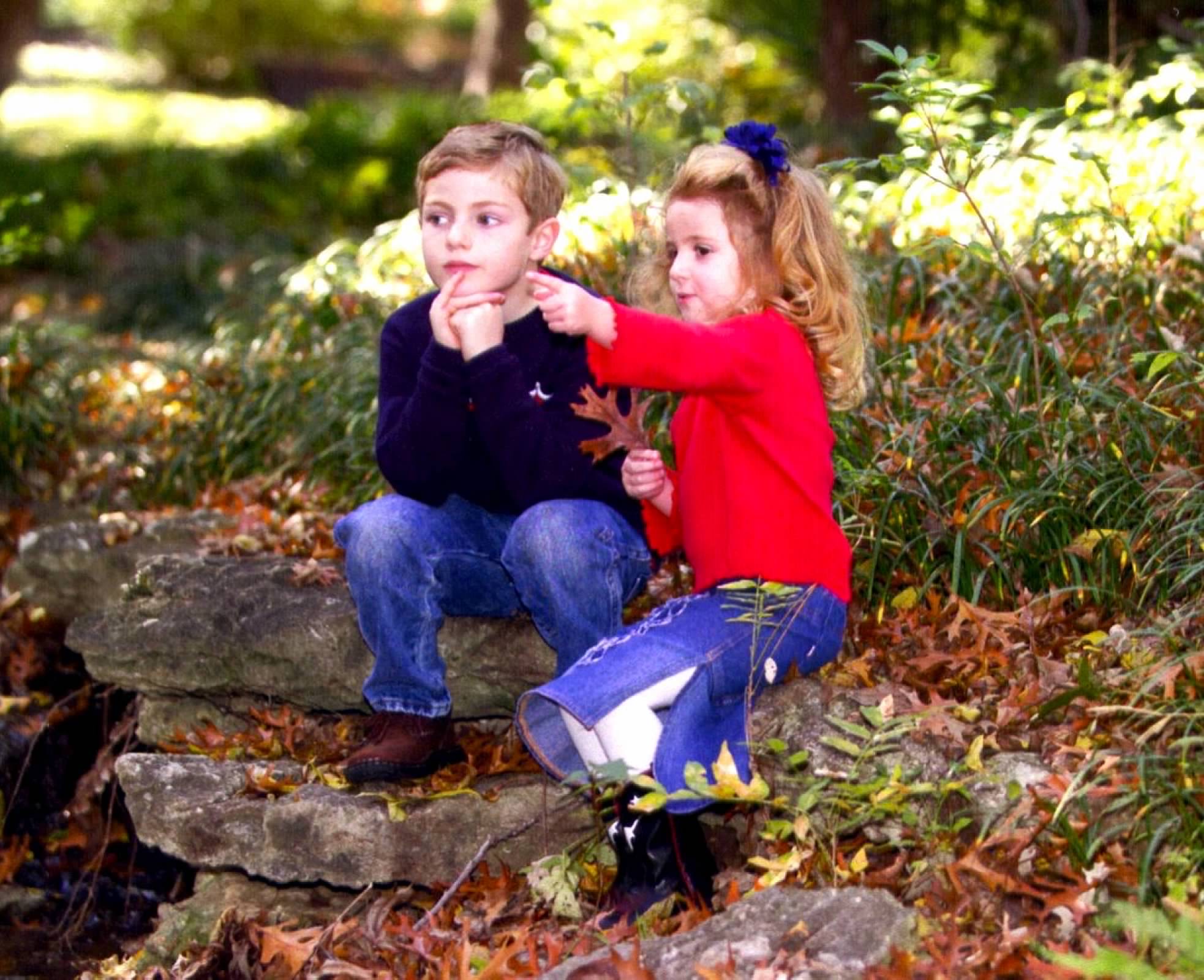 Young Sam and Annie playing in fall leaves